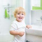 child by bathroom sink